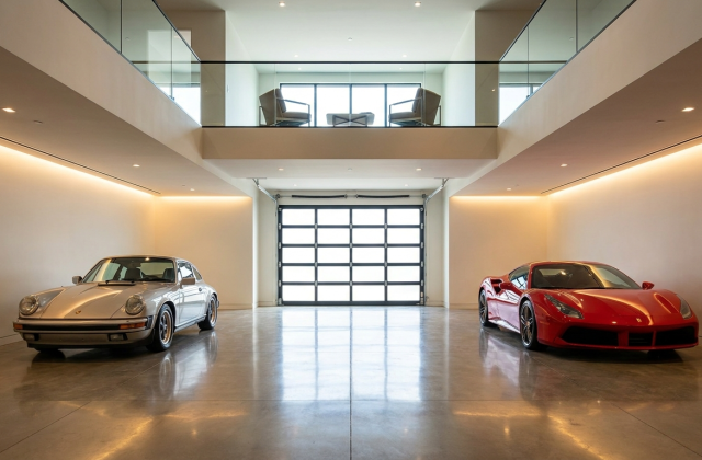 Interior of a garage condo with collector cars and a mezzanine loft above